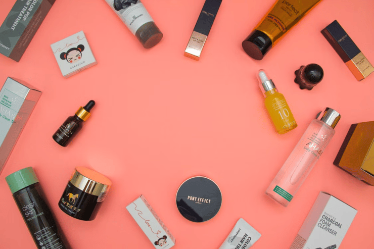 Beauty Products Scattered on Salmon Pink Background