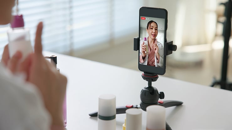 an image showing a woman recording on her phone