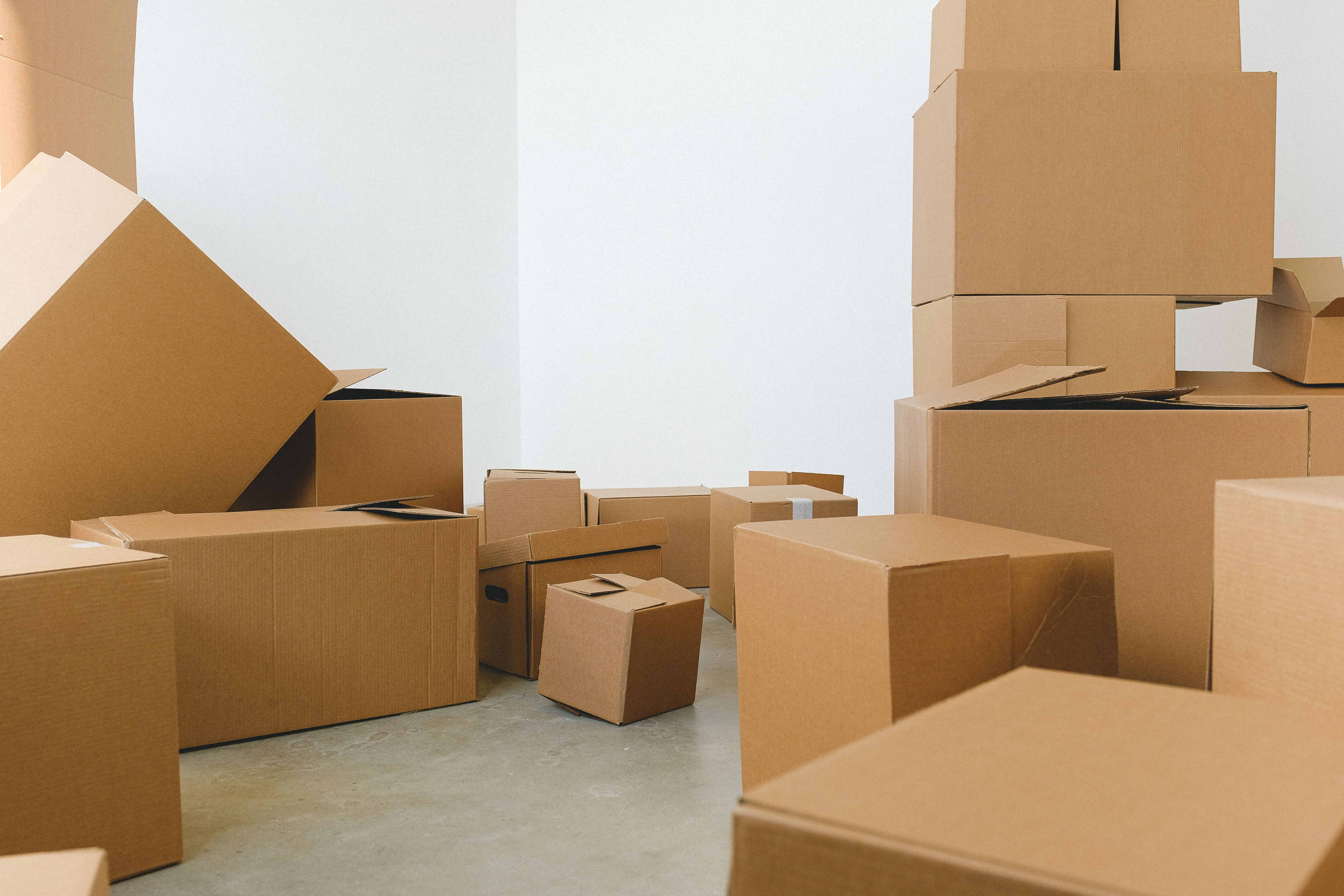 A collection of cardboard boxes scattered in an empty room, suggesting a move or relocation.